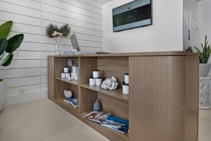 Contemporary reception desk with decor and TV in a professional office setting.