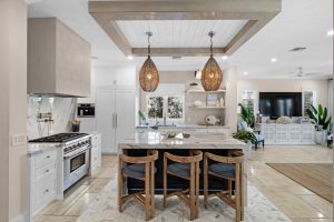 Contemporary kitchen with island, pendant lighting, and white cabinetry.