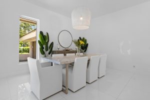 Bright modern dining room with white chairs and minimalist decor.