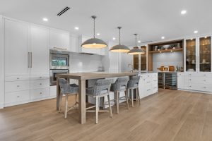 Contemporary kitchen with island, pendant lights, and built-in cabinets.