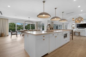 Spacious modern kitchen with island, pendant lights, and large windows.
