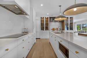 Contemporary white kitchen with island and pendant lighting.